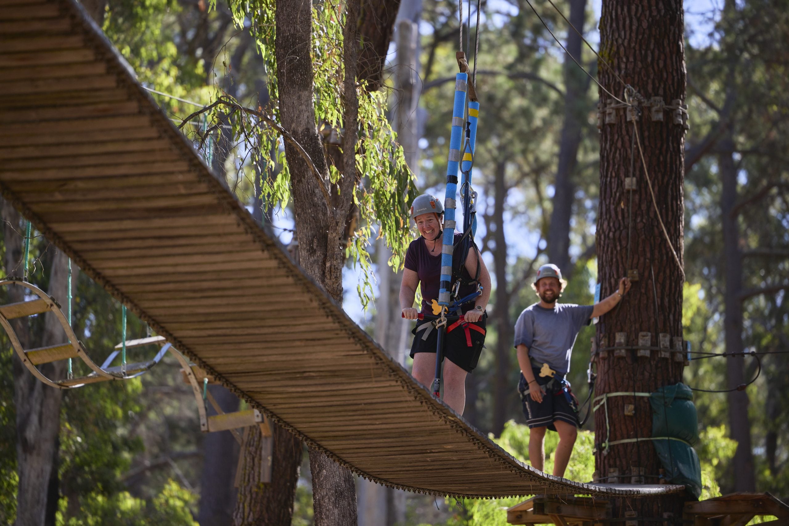 Person riding a scooter in the treetops, having a great time at Forest Adventures
