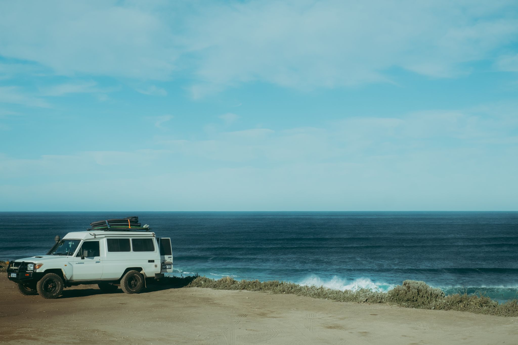 White 4WD next to the ocean. Credit Ryan Murphy