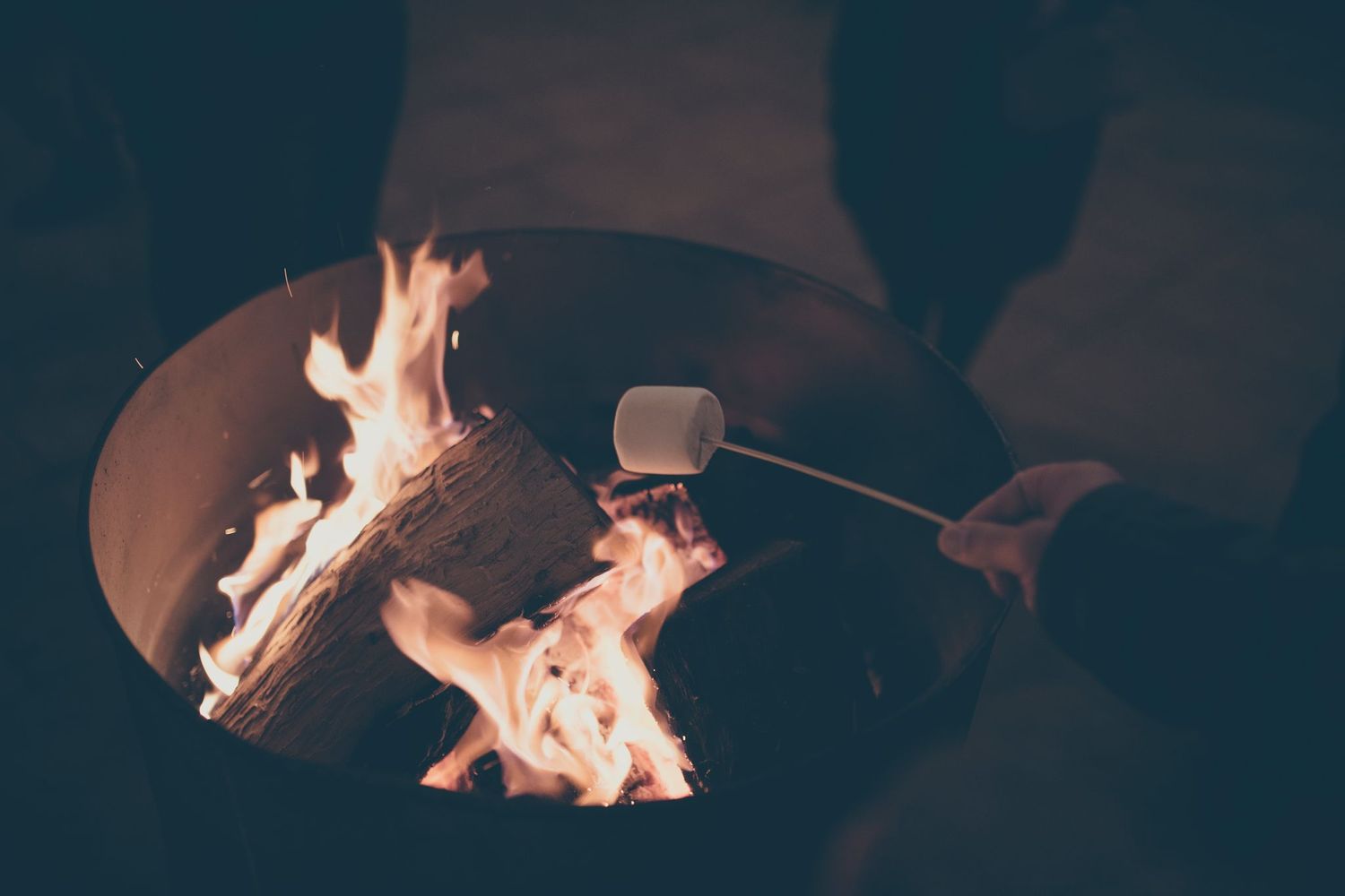 Roasting marshmallows over fire at the Cabin Fever Launch Party. Credit G Becker Photo