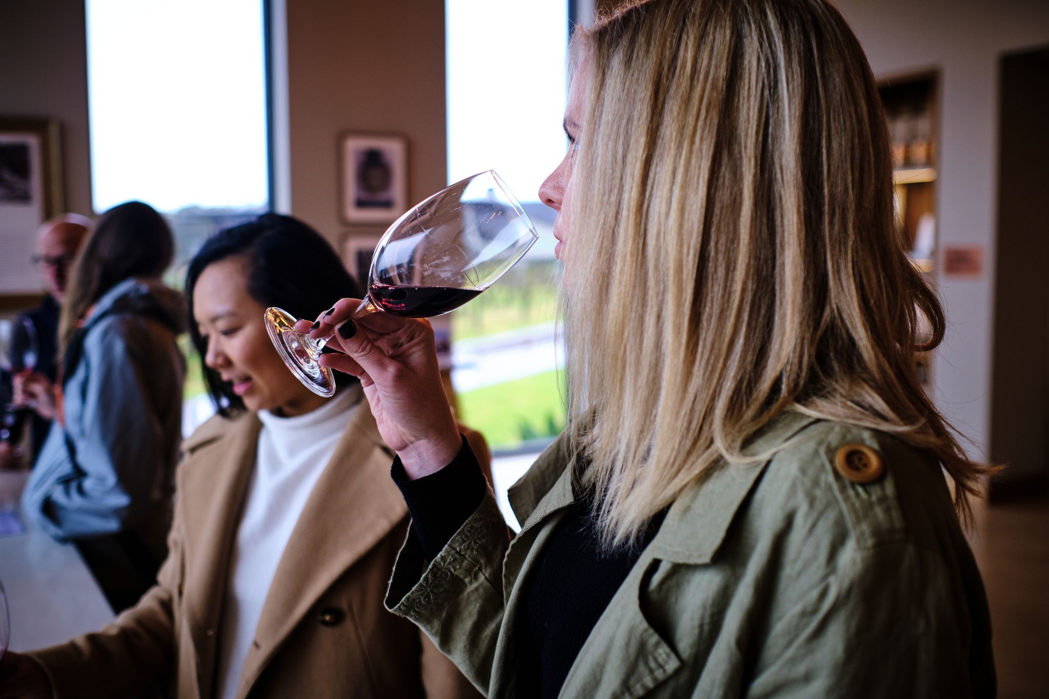 Woman tasting red wine in winter at Amelia Park. Credit Russell Ord.