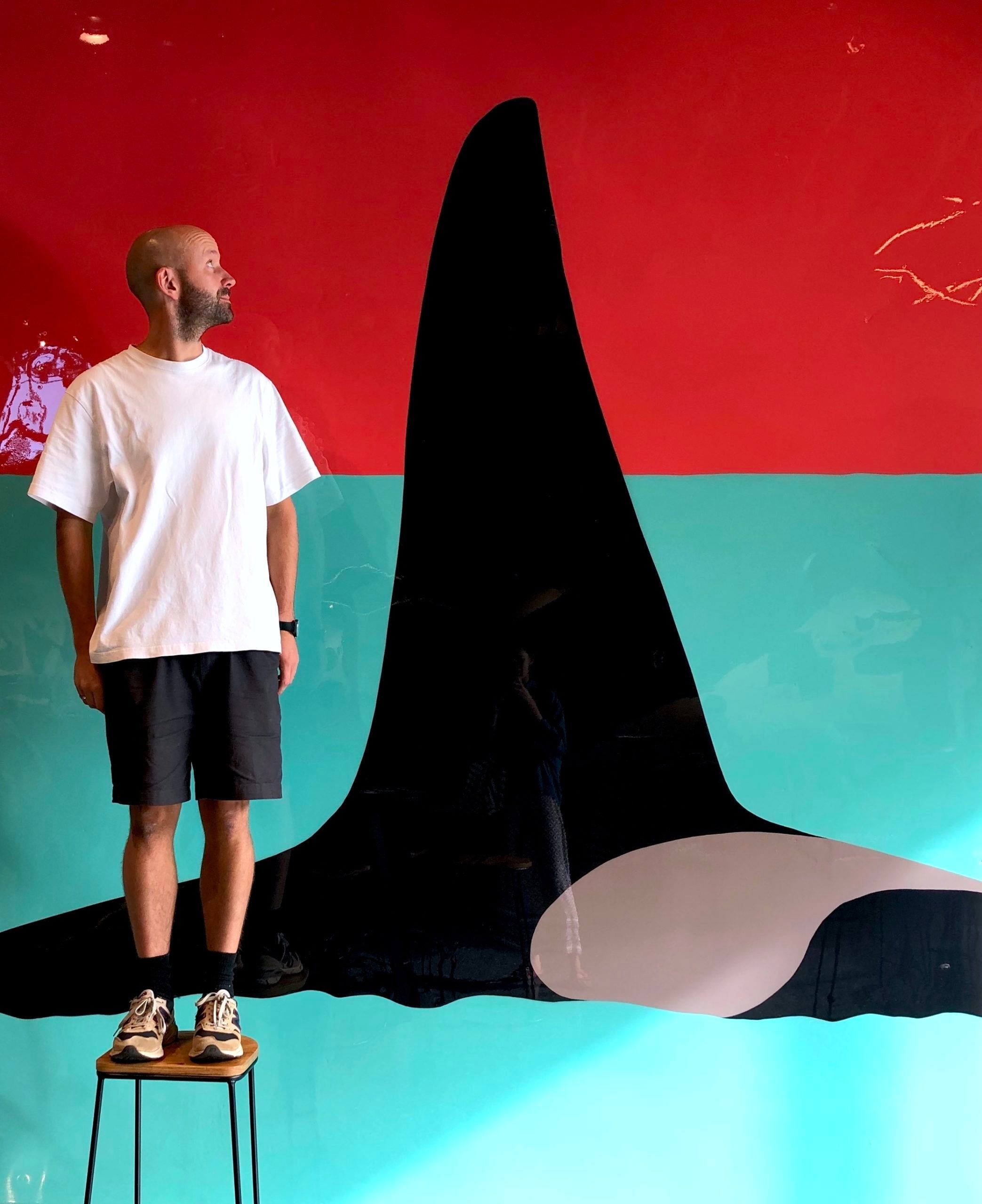 Ian Daniell standing next to his orca painting. Part of Margaret River Region Open Studios.