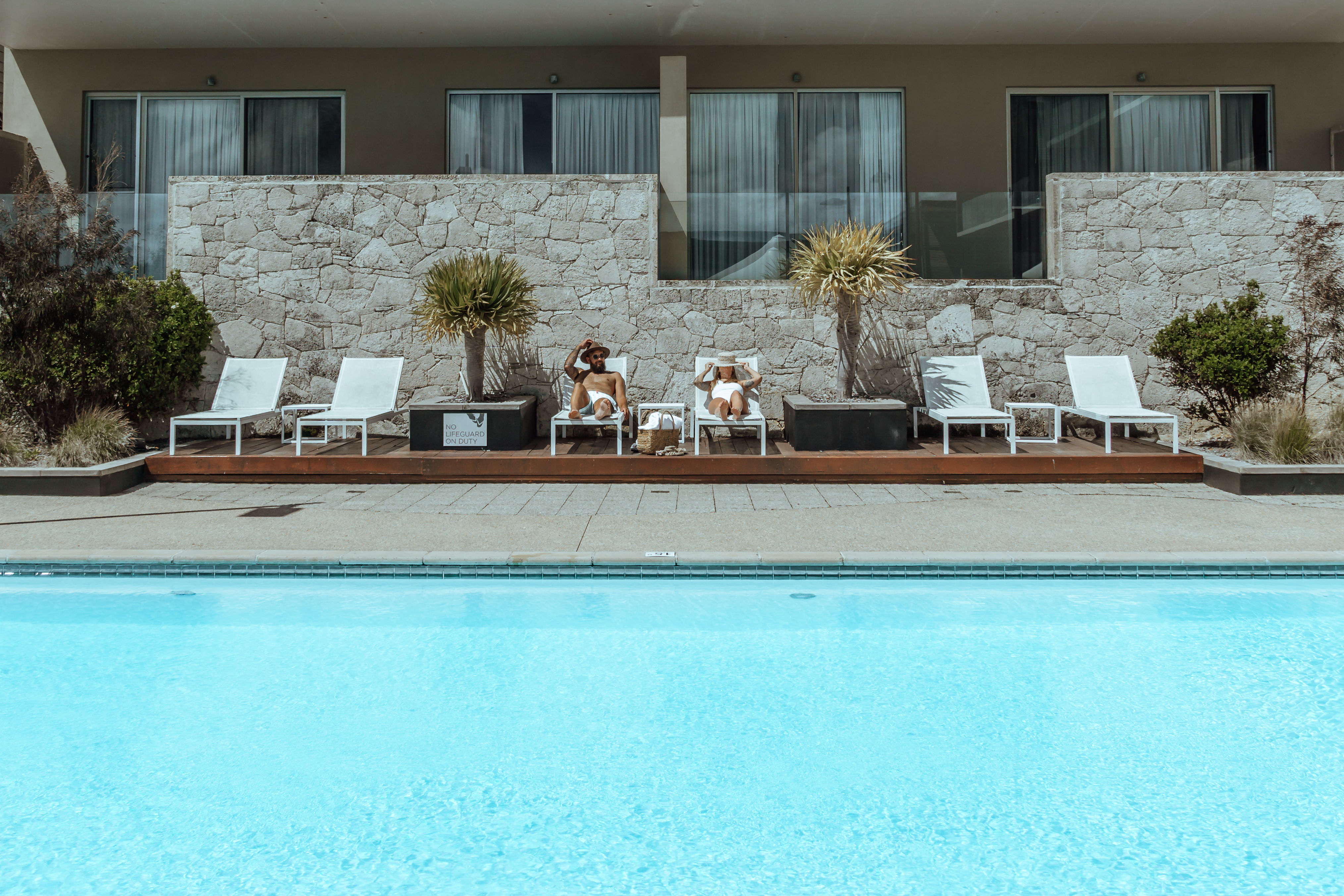 Couple relaxing next to swimming pool at Smiths Beach Resort.