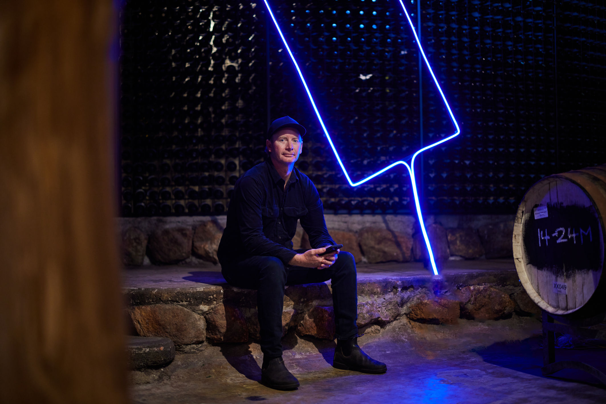 man sitting in a dark cellar next to a fluro light