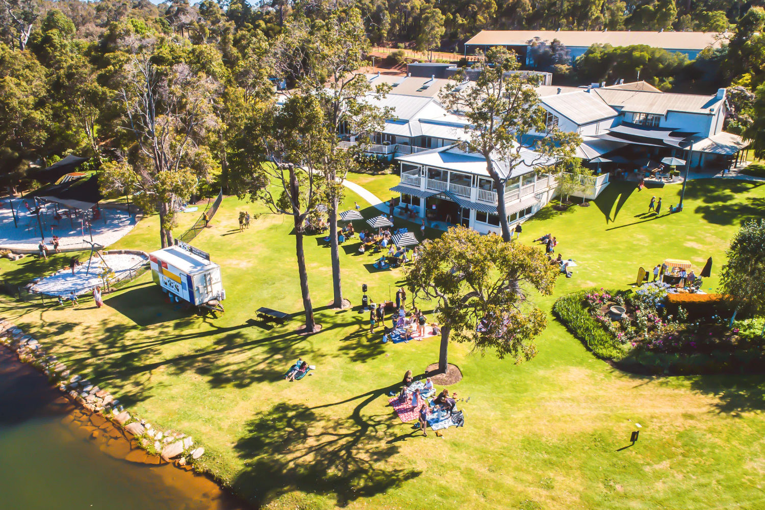 Photo from the air of Aravina Estate. The grass is green and there are people walking around.