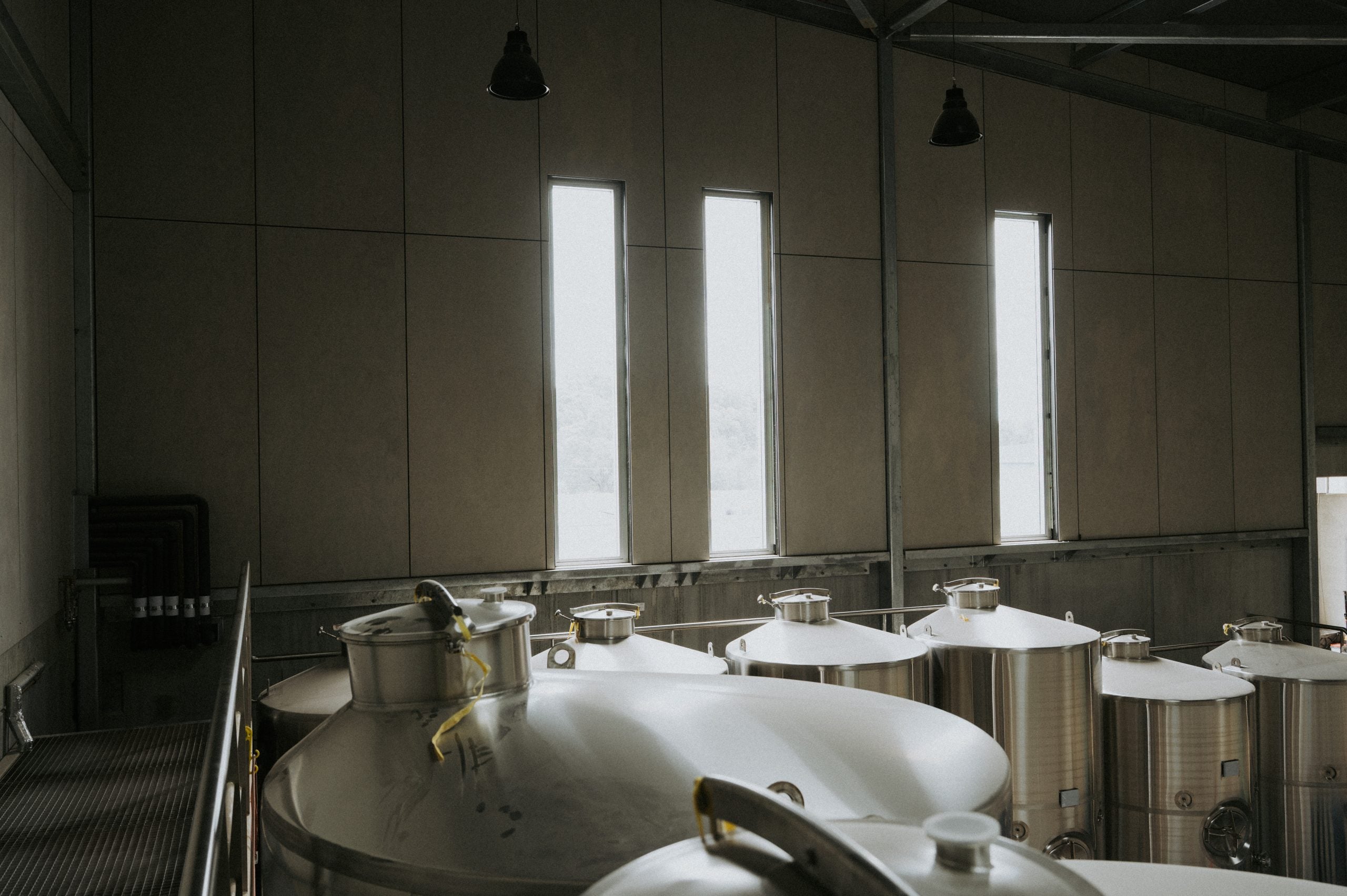 Artistic image of metal wine barrels under windows.