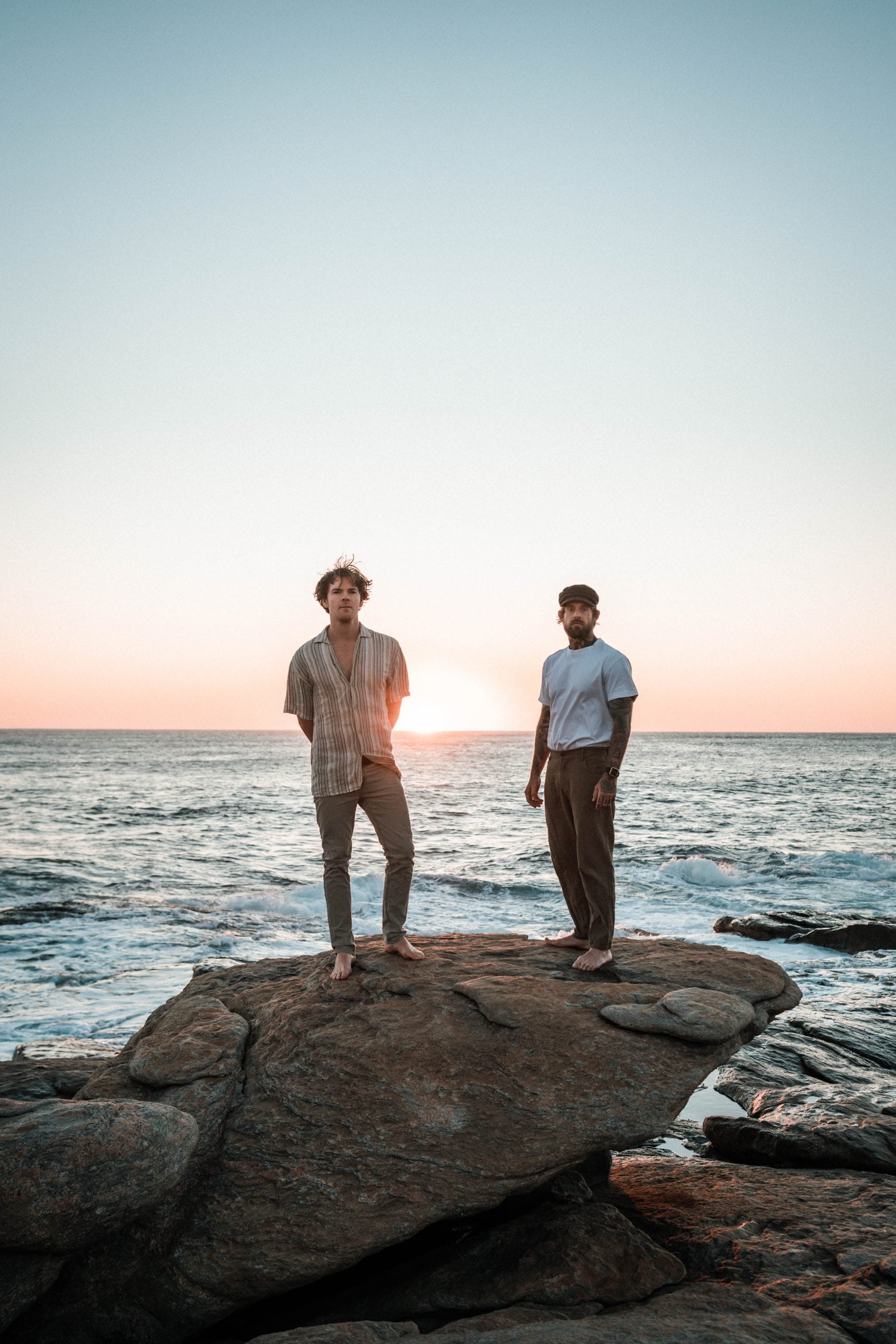 Salt Water band members standing on rocks at Redgate beach.