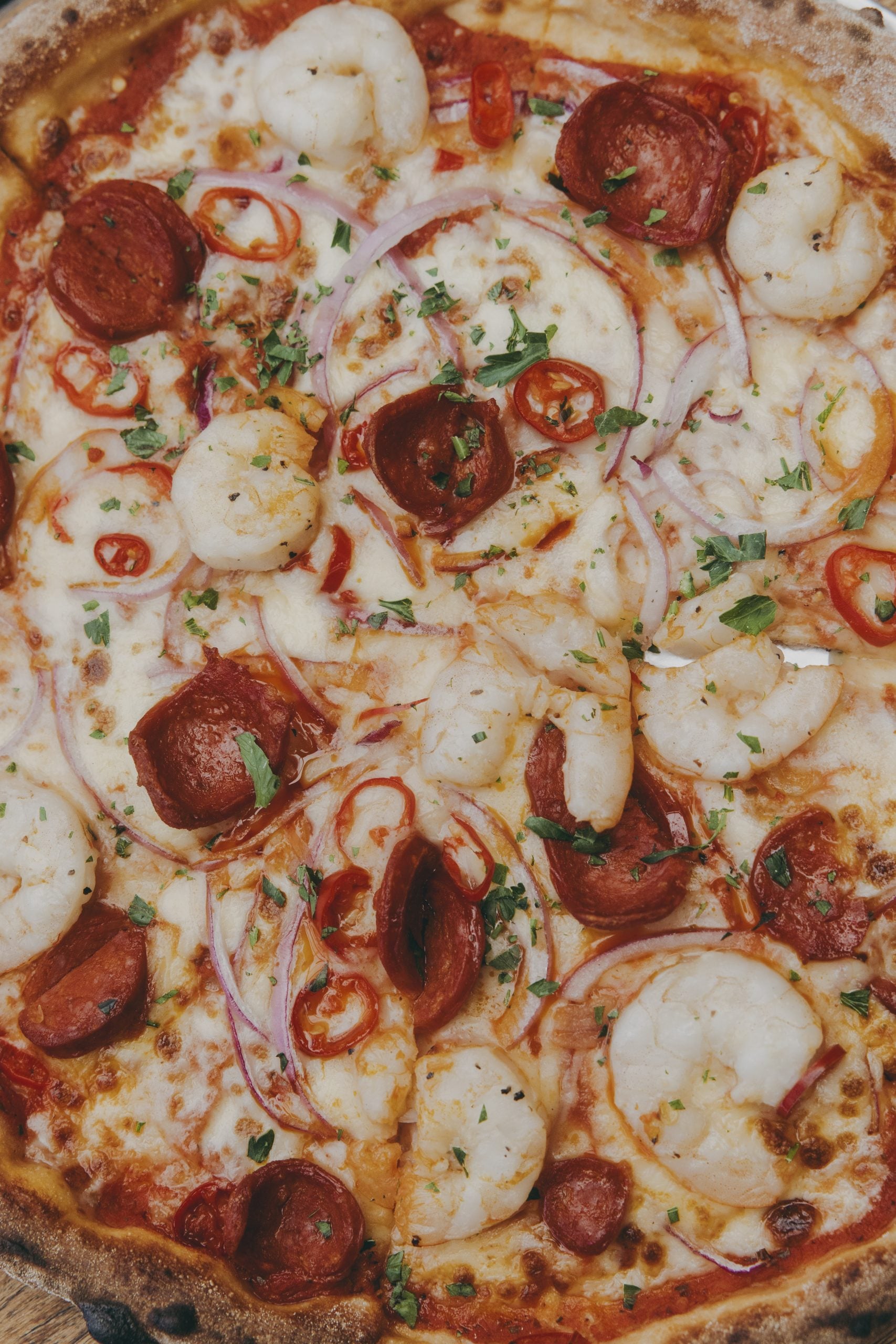 Close up of pizza with prawns and pepperoni.