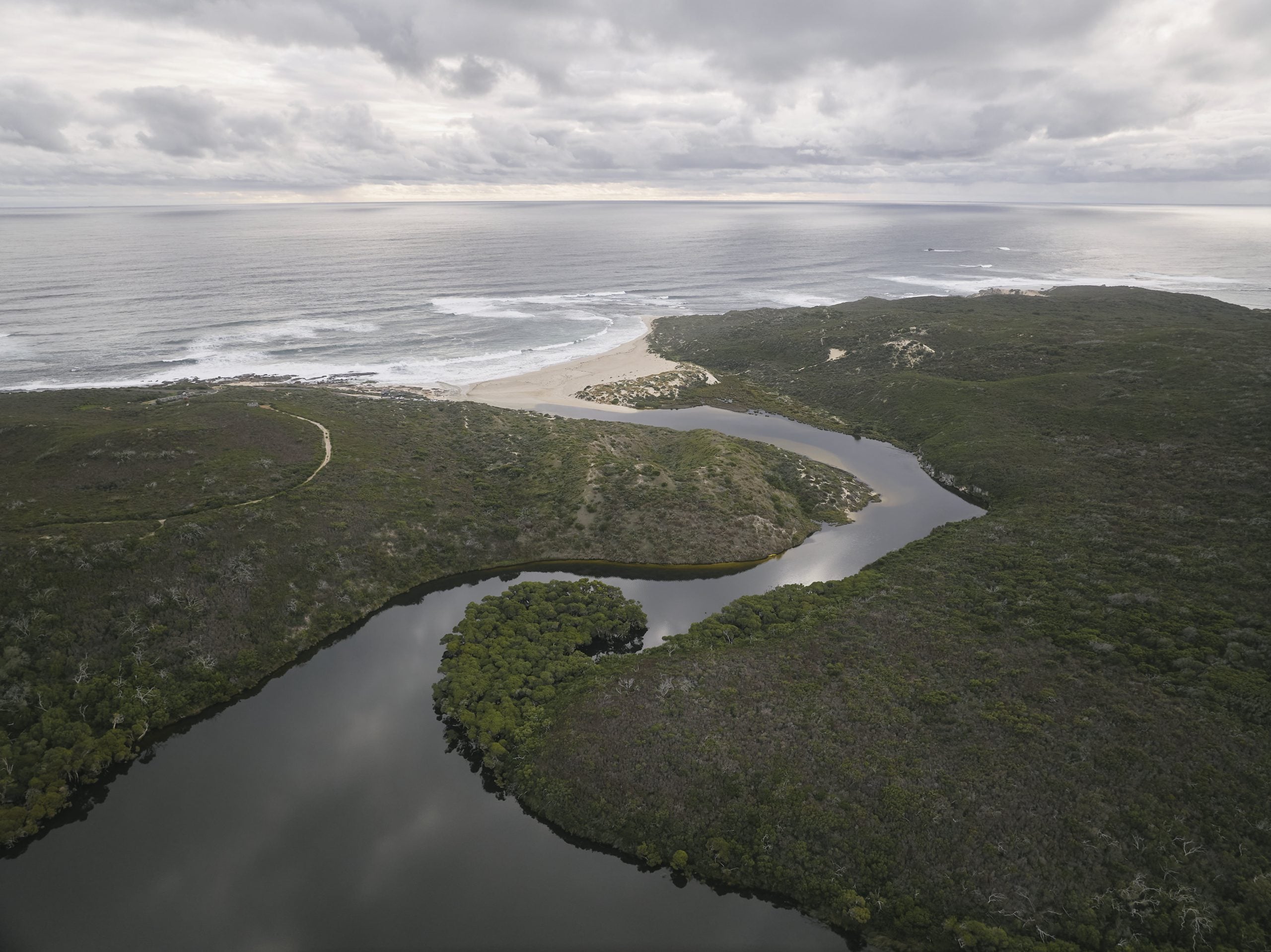 aerial view of a river running through a lush green field