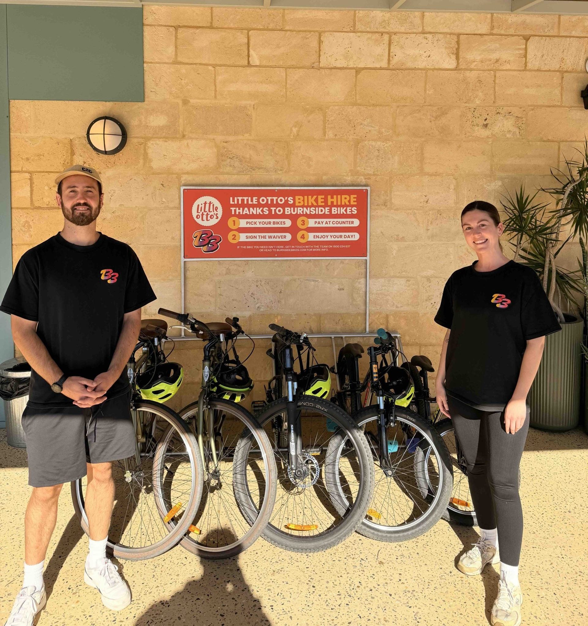Two people standing next to bikes for hire