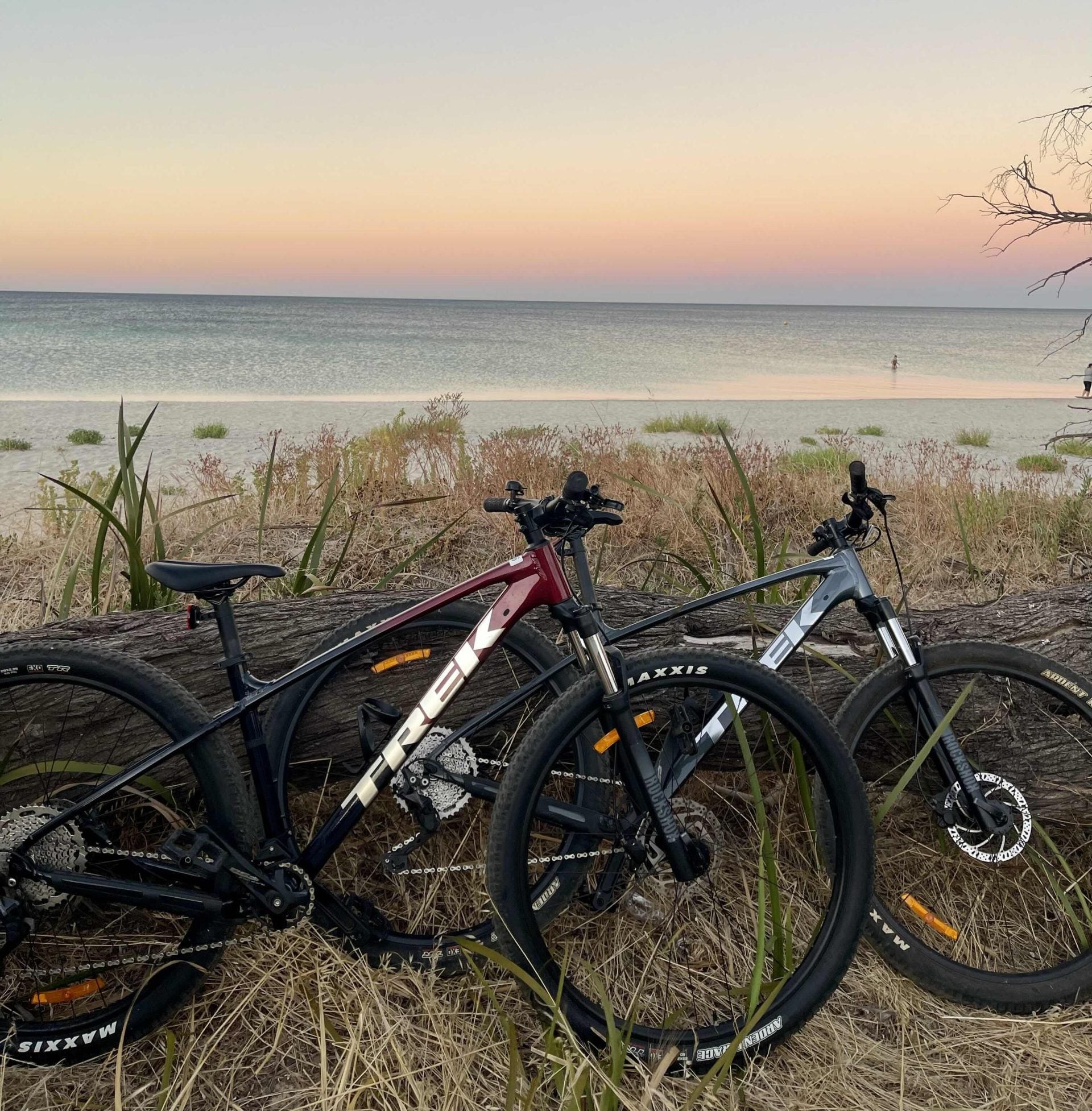 Bicycles near the ocean while the sun is low providing a nice afterglow