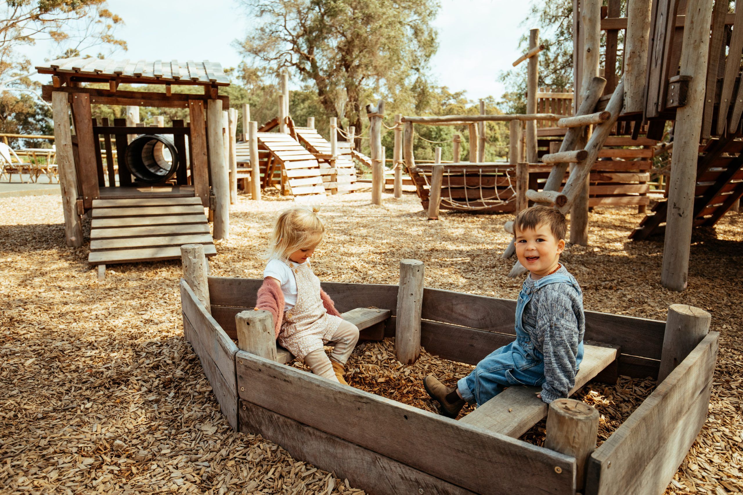 Kids in a wooden boat at Swings & Roundabouts